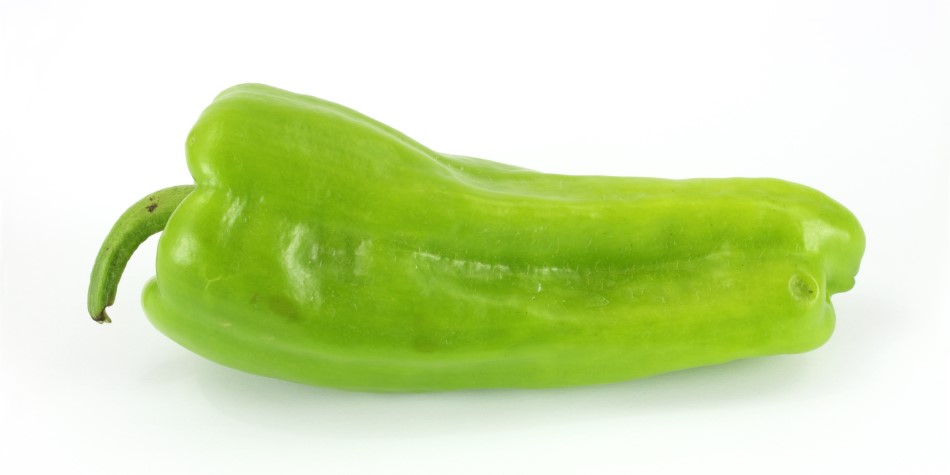Photo of bright green Cubanelle pepper on white backdrop
