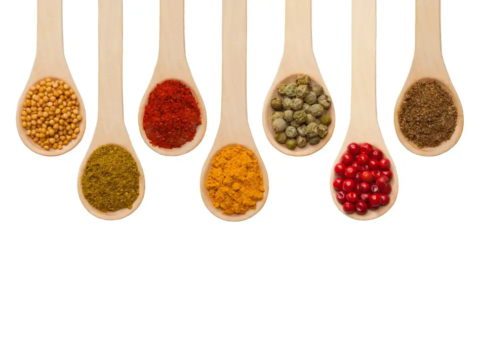 Photo of a variety of spices on wooden spoons