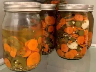 photo of jars of pickled Jalapenos and carrots chilled in the fridge.