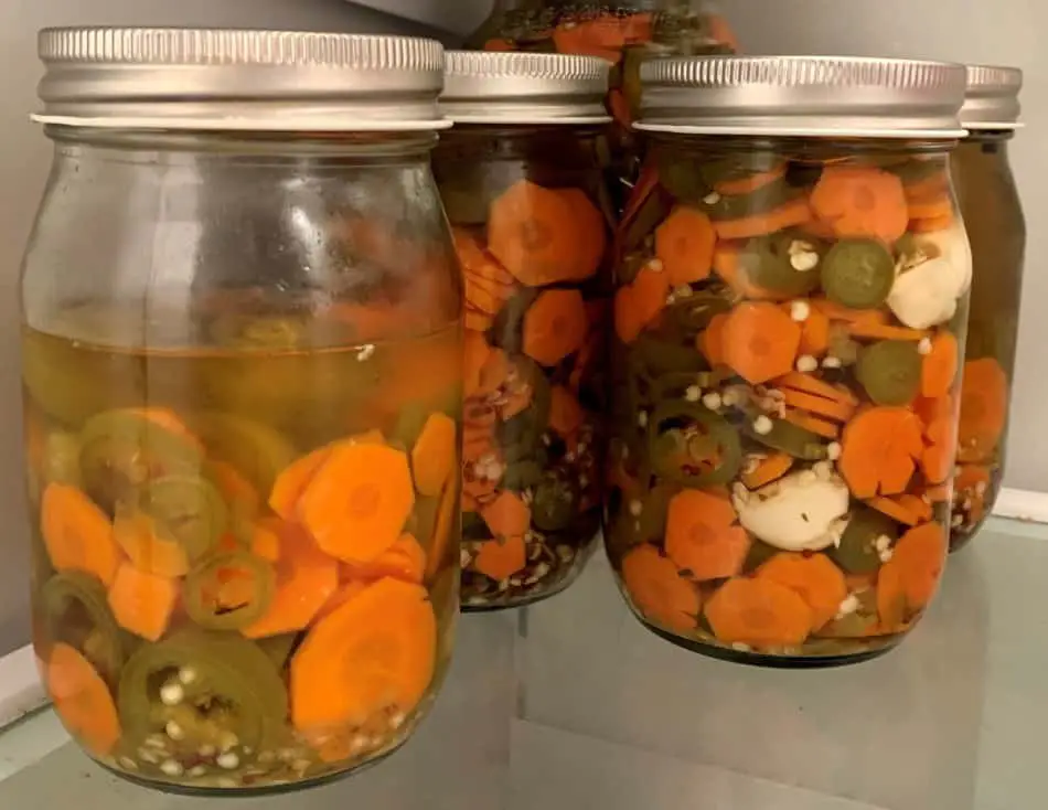 photo of jars of pickled Jalapenos and carrots chilled in the fridge.