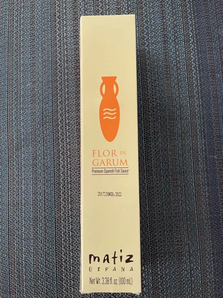 Photo of Matiz Espana Garum fish sauce in its box which is light beige and orange