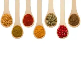 Photo of a variety of spices on wooden spoons