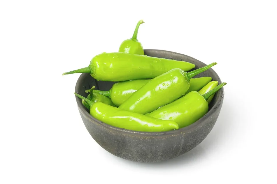 A bunch of banana peppers sitting in a small dark wooden bowl