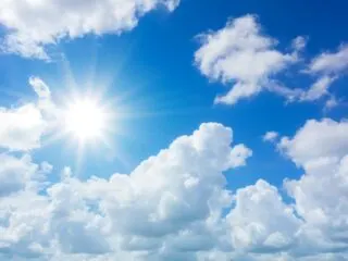 Photo of sunshine and clouds against a blue sky backdrop