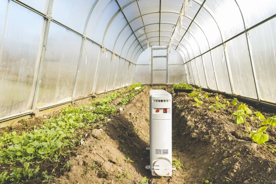 Photo of a heater inside a greenhouse warming the plants