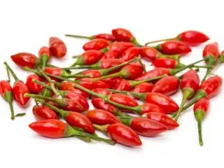 Photo of a bunch of piri piri peppers on a white backdrop