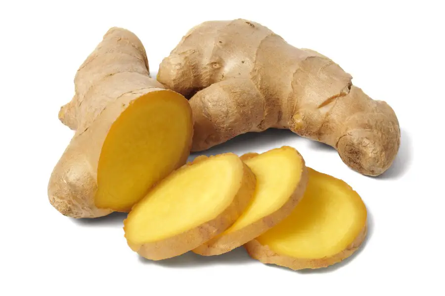 Photo of whole and sliced fresh ginger set on a white background