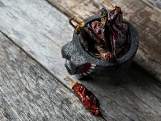 Photo of morita chili peppers sitting in a mortar.