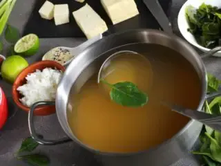 Photo of Dashi broth in a stainless steel sauce pan surrounded by other ingredients