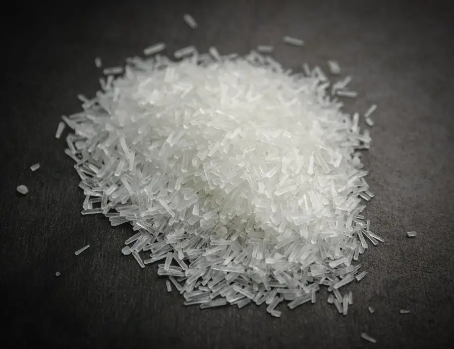 Close up picture of msg crystals piled on top of a slate backdrop